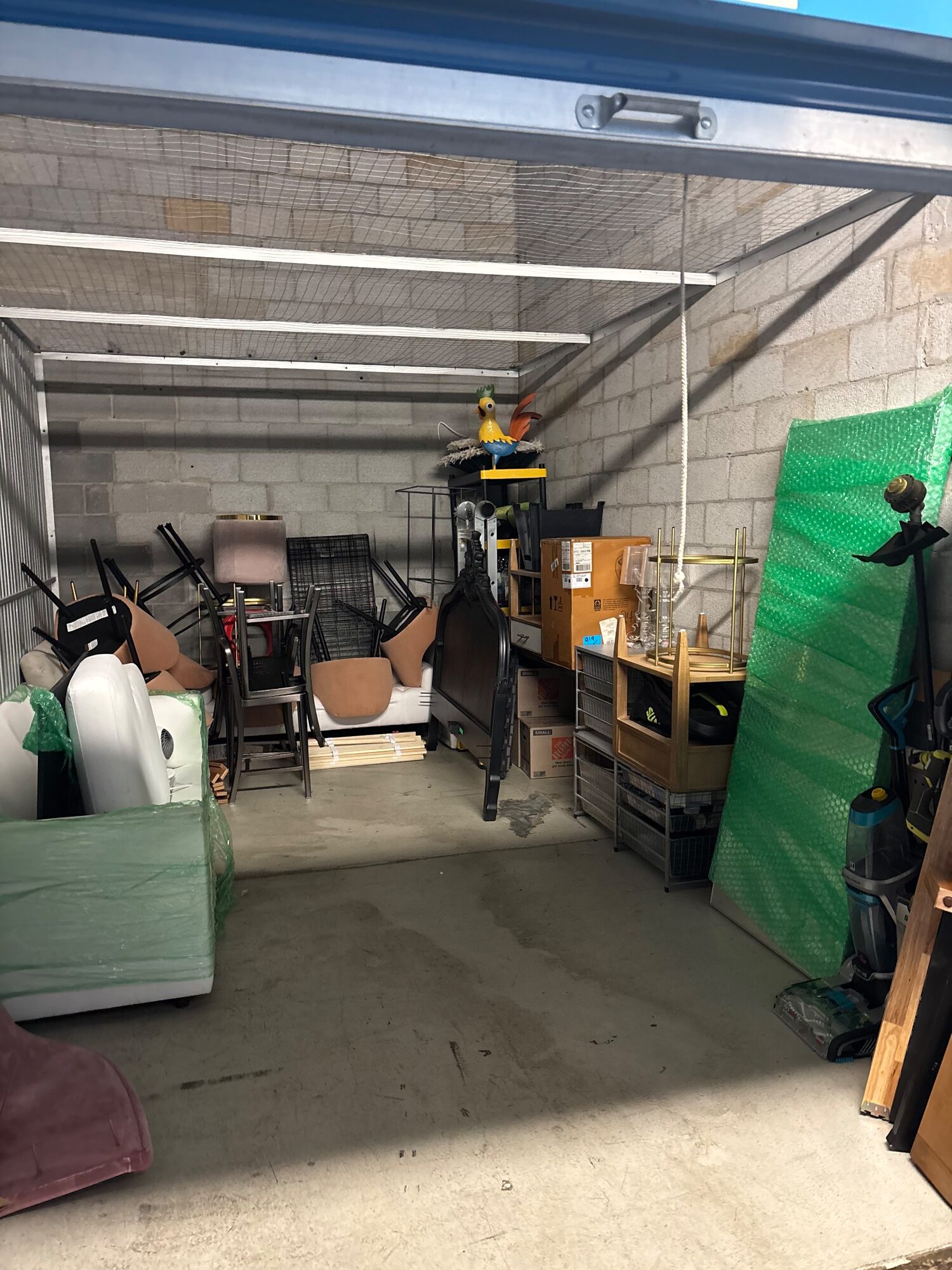 Storage unit with furniture and household goods stacked along both walls