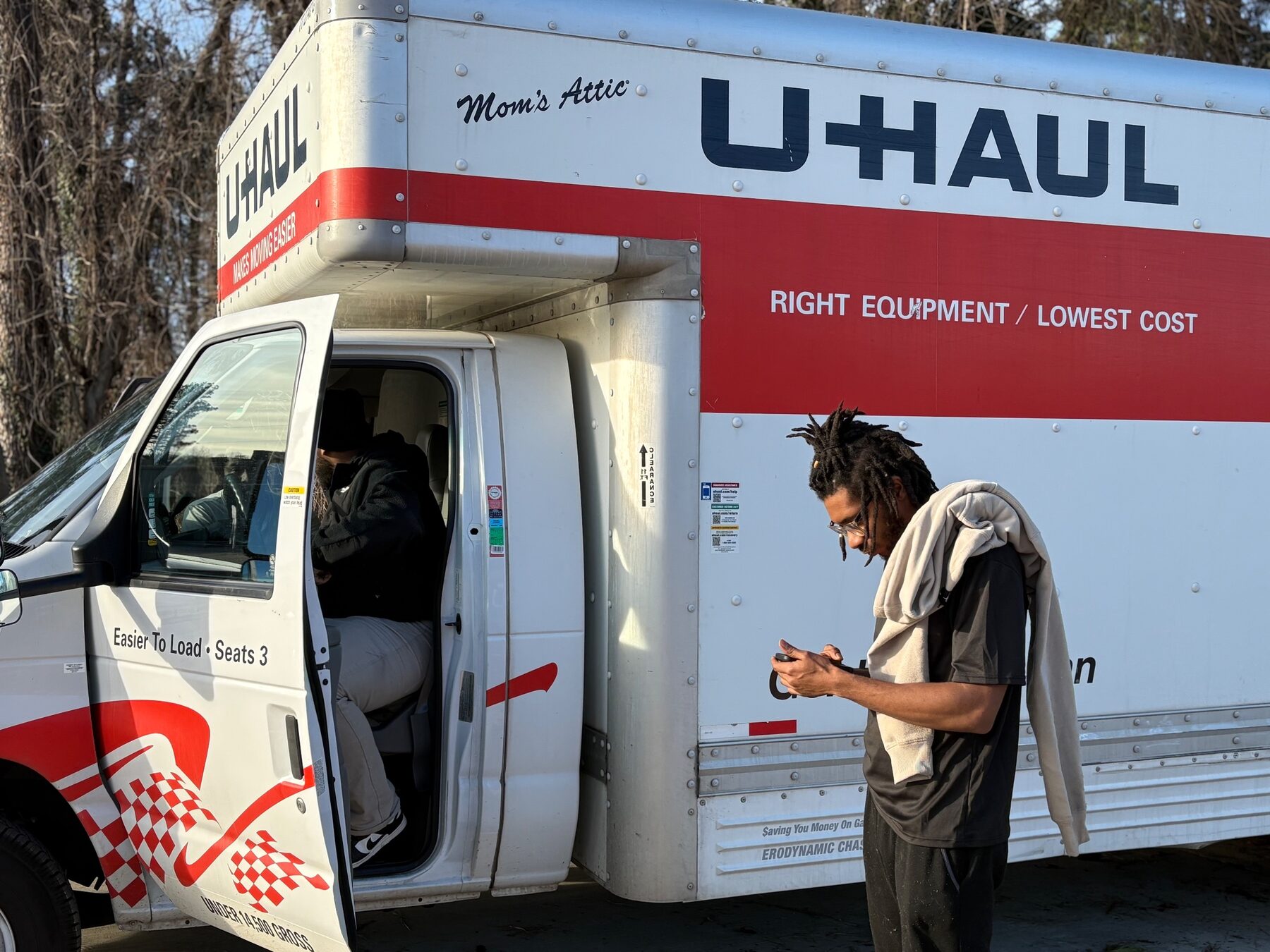 Clays Moving crew member beside a rental box truck with the cab door open